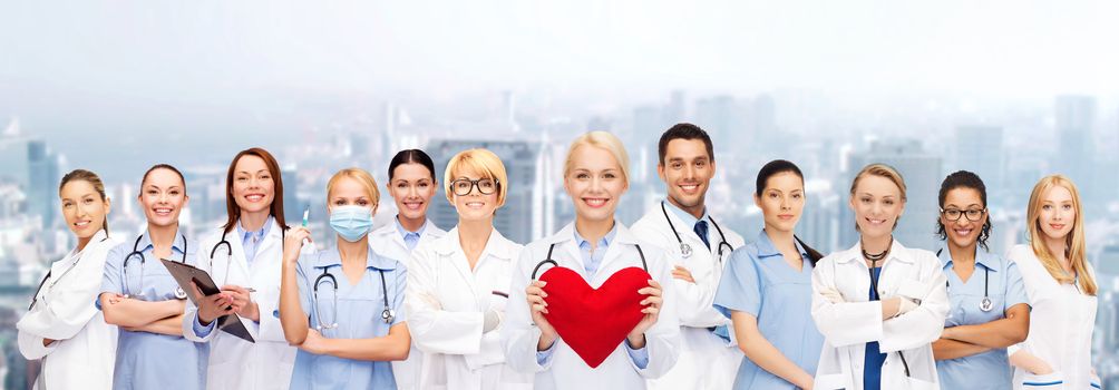 healthcare and medicine concept - smiling doctors and nurses with red heart