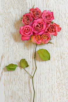 Bouquet of dried roses on table wood
