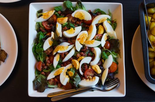 Fresh salad with tomato, lettuce and quail eggs. Top view