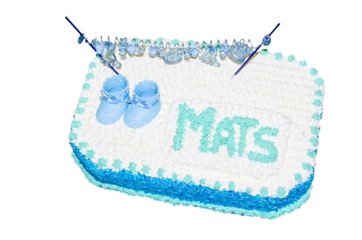 Garnished children birthday cake with icing, inscription and little baby shoes.