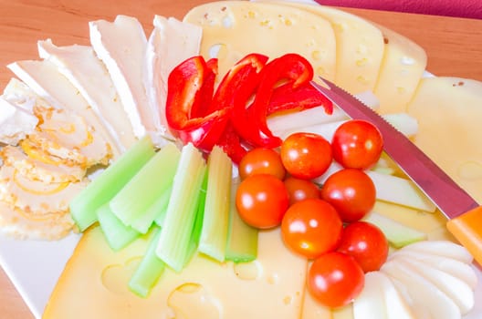 Cheese platter with fruits and vegetables / cheese plate garnished.