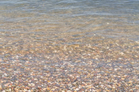 Riverside landscape, view of small pebbles in a clear river.