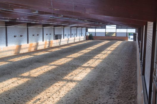View in an indoor riding arena. The riding school is suitable for dressage horses.