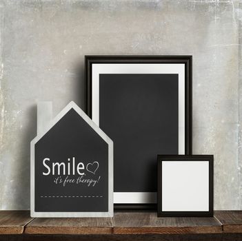 Chalkboard with quote and frames on old table