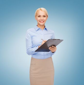 business and education concept - friendly young smiling businesswoman with clipboard and pen