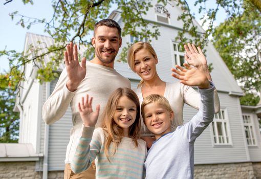 family, generation, home, gesture and people concept - happy family standing in front of house waving hands outdoors