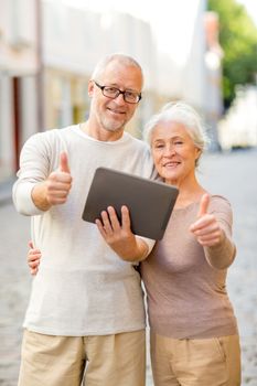 age, tourism, travel, technology and people concept - senior couple with tablet pc computer showing thumbs up gesture on street