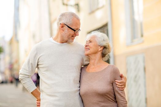 family, age, tourism, travel and people concept - senior couple hugging on city street