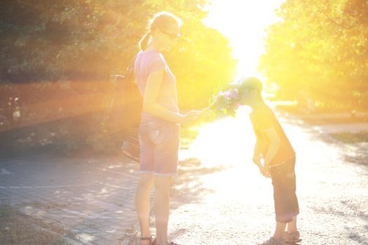 Blurred photo of walking woman with her son on sunrise