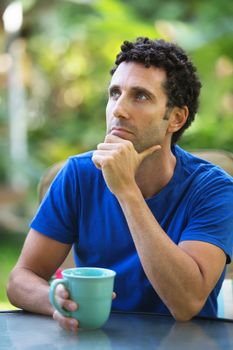 Pensive Caucasian adult sitting outdoors in Maui