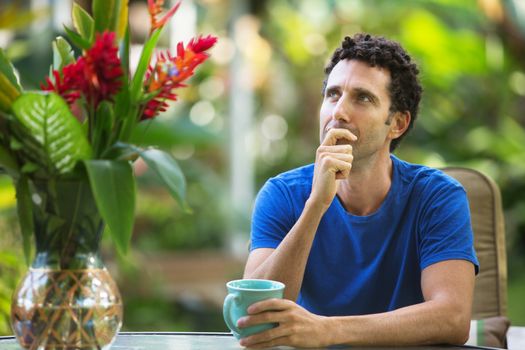 Single adult man in blue outdoors thinking about something