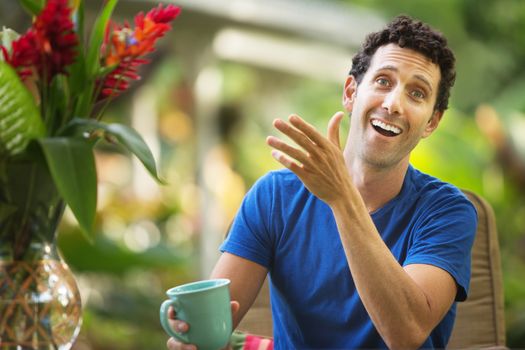 Single Caucasian adult gesturing with hand and laughing