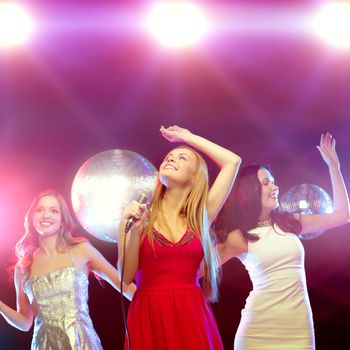 party, new year, celebration, friends, bachelorette party, birthday concept - three women in evening dresses dancing and singing karaoke