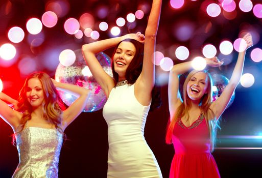 new year, celebration, friends, bachelorette party, birthday concept - three beautiful women in evening dresses dancing in the club