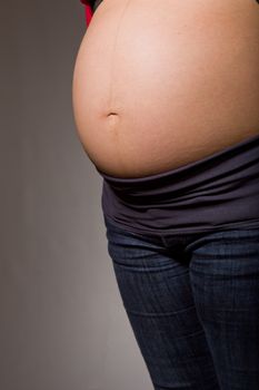 Closeup of pregnant woman at black background