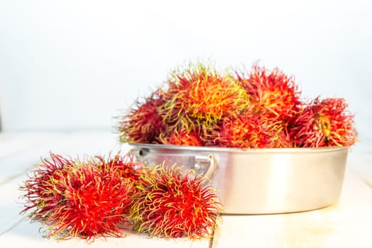 Red rambutan Nephelium lappaceum on white board. Fruit tropical tree of the family Sapindaceae , native to South - East Asia , cultivated in many countries in the region