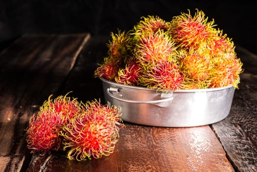 Red rambutan Nephelium lappaceum on broun board. Fruit tropical tree of the family Sapindaceae , native to South - East Asia , cultivated in many countries in the region