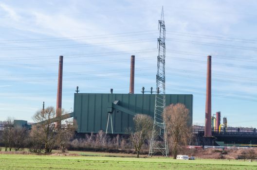 Power plant to generate electricity in the industrial area on a green meadow.