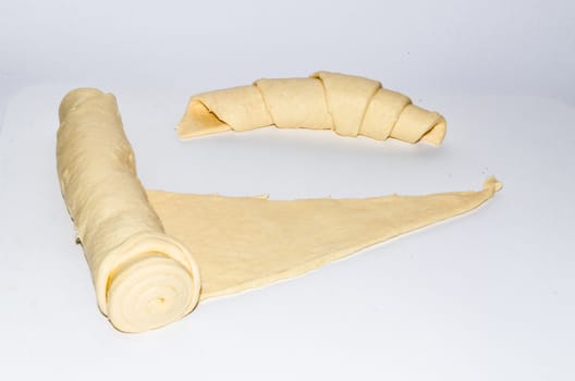 Fresh raw croissant dough on a white background