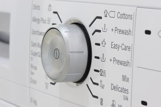 closeup of new white laundry or washing machine, selective focus on control elements