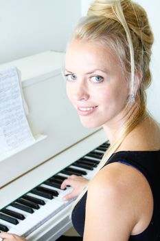 Woman playing with musical notes on a white piano