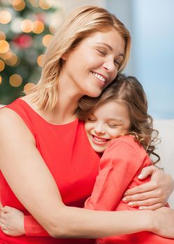 christmas, x-mas, happiness concept - hugging mother and daughter