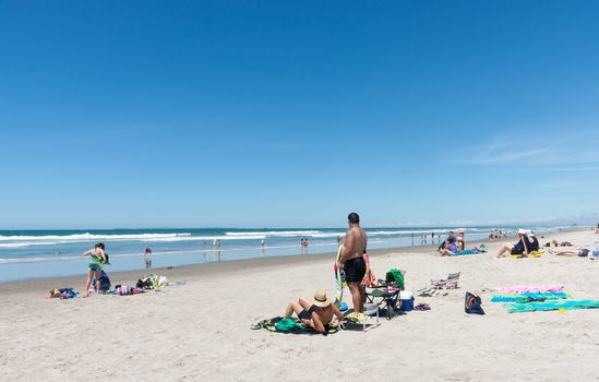 People enjoying a summer day at beach Omanu Tauranga New Zealand.