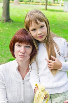 Photo of mother and daughter eating banana