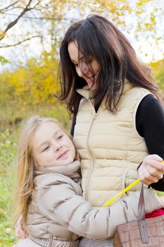 Photo of playing mother and daughter in autumn