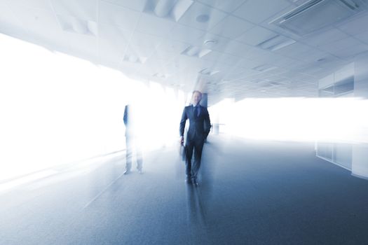 Abstract blurry portrait of walking businessman in office