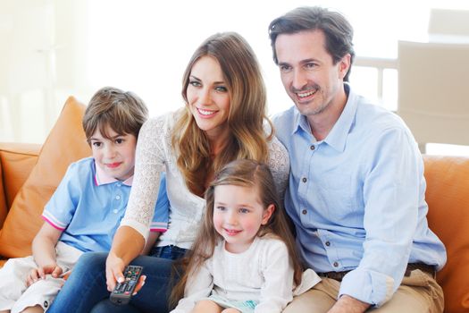 happy family watches movie while sitting on the couch