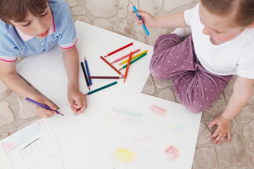 brother and sister drawing pictures with coloring pencils