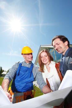 foreman shows house design plans to a young couple