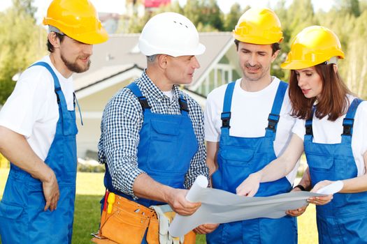 team of workmen looking at house design