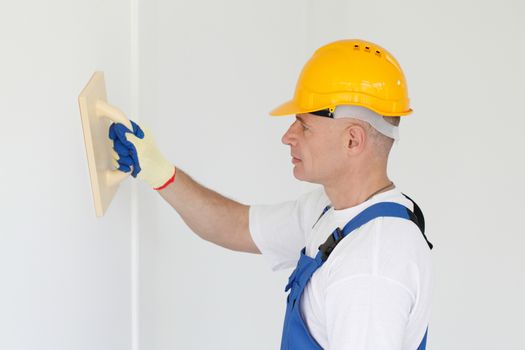 portrait of workman polishing wall