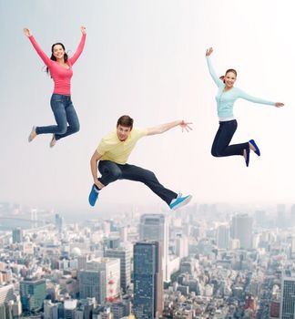 happiness, freedom, friendship, movement and people concept - group of smiling teenagers jumping in air over city background