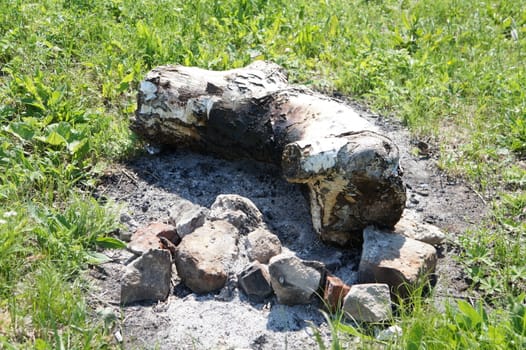 charred remains of wood ashes and scorched grass