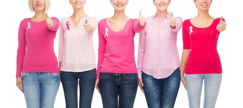 healthcare, people, gesture and medicine concept - close up of smiling women in blank shirts with pink breast cancer awareness ribbons over white background