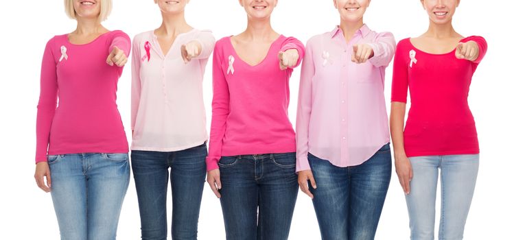 healthcare, people, gesture and medicine concept - close up of smiling women in blank shirts with pink breast cancer awareness ribbons pointing on you over white background