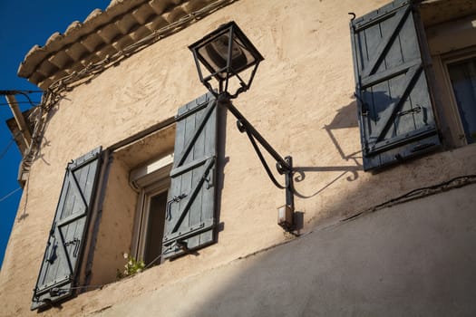 Window with coloured shutter in a small village in Provence, France