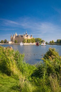 Schwerin Castle (Schweriner Schloss) reflected in the lake with some sailing boats