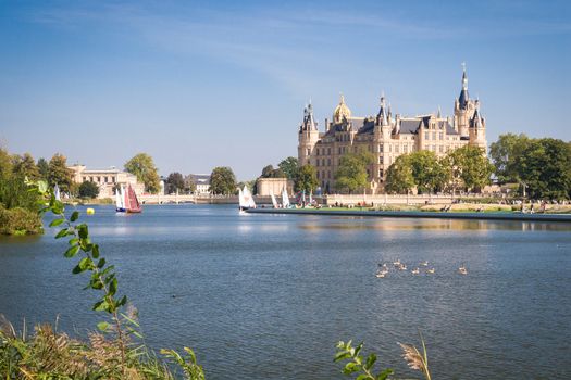 Schwerin Castle (Schweriner Schloss) reflected in the lake with some sailing boats