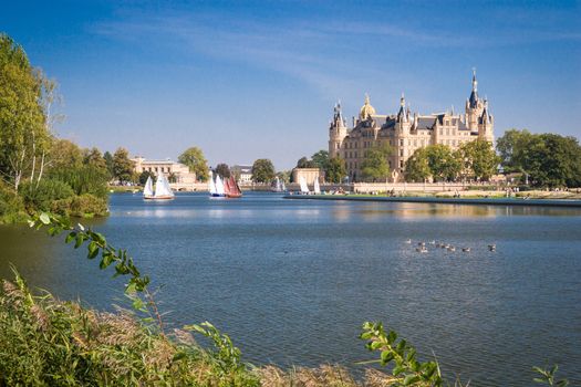 Schwerin Castle (Schweriner Schloss) reflected in the lake with some sailing boats