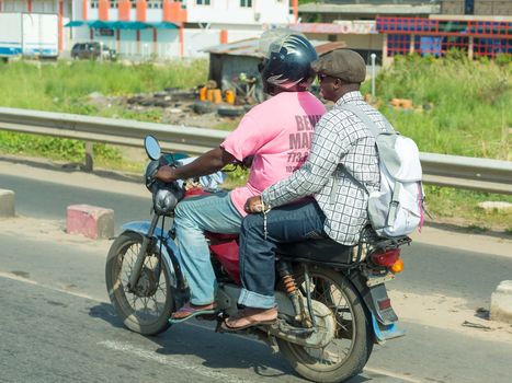 Cotonou, Benin: May 26: A man rides a hired Motorcycle taxi, the most common means of hired transportation in the city, on May 26, 2015 in Cotonou, Benin.