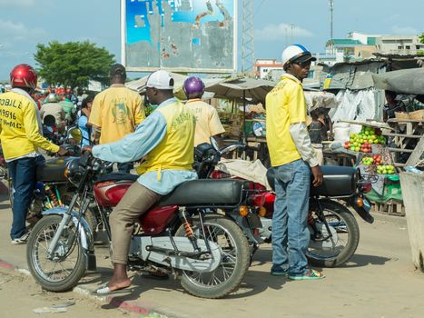 Cotonou, Benin: May 26: A man rides a Motorcycle taxi, the most common means of hired transportation in the city, on May 26, 2015 in Cotonou, Benin.