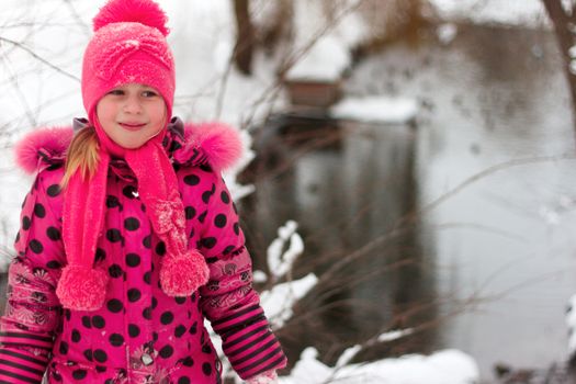 A little girl playing in a snow pile.