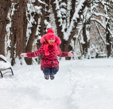 A little girl playing in a snow pile.