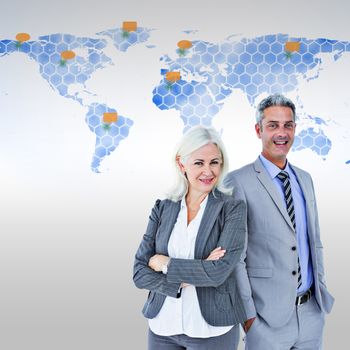  Smiling businesswoman and man with arms crossed against world map 