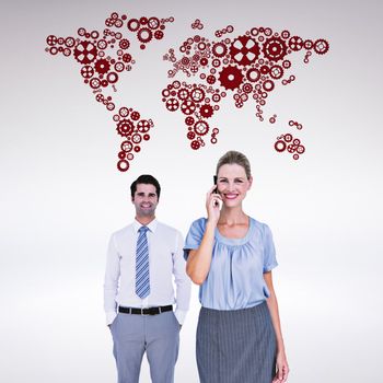 Businesswoman having phone call while her colleague posing against grey background