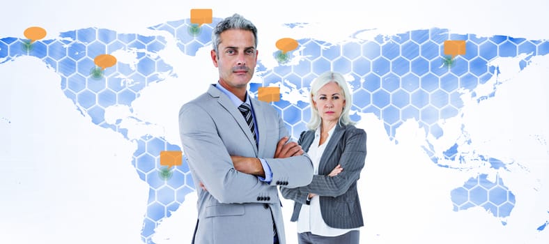  Smiling businesswoman and man with arms crossed against world map 